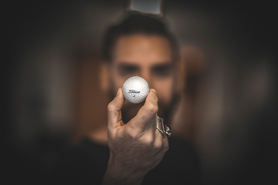 Muž držící golfový míček